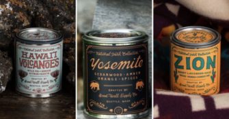 candles in tin cans positioned in front of volcanic rock, wood, and a colorful blanket
